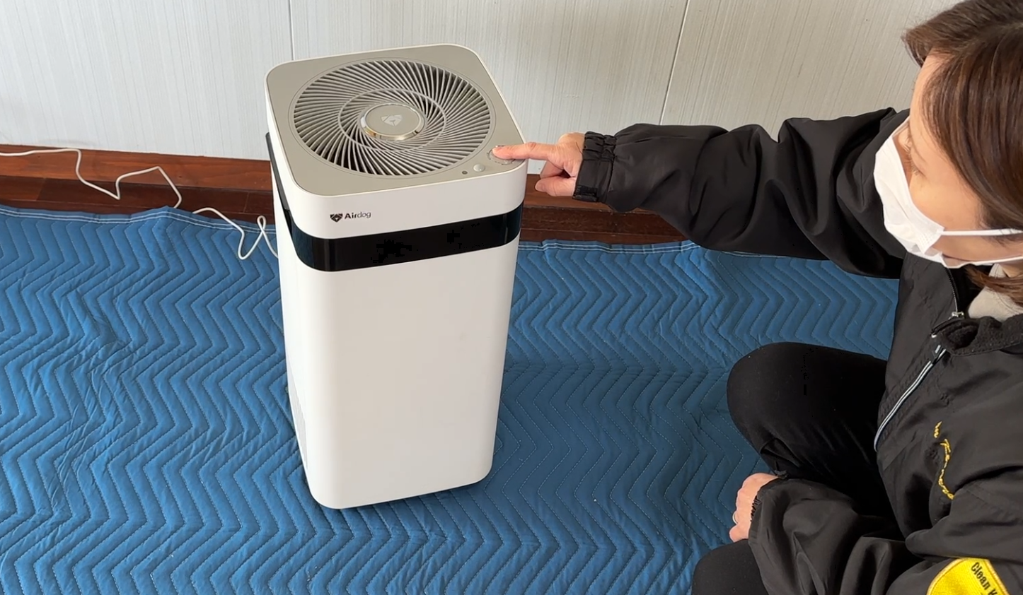 電源が入らなくなったと修理依頼を受けたAirdog（X3s）。弊社スタッフの女性が、分解を始める前に電源ボタンを押し、動作確認を行っている様子。