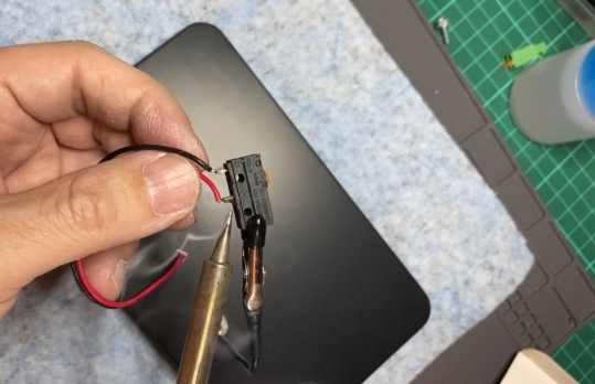 エアドッグ修理中にマイクロスイッチの配線をはんだ付けしている様子